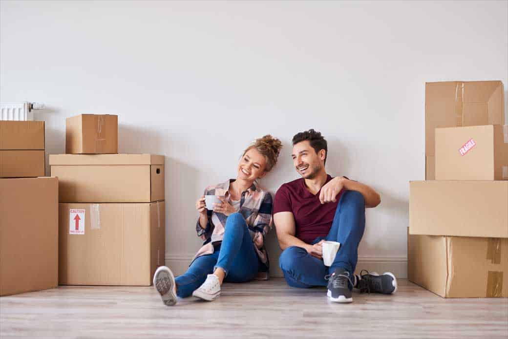 happy-couple-with-coffee-cups-relaxing-their-new-home