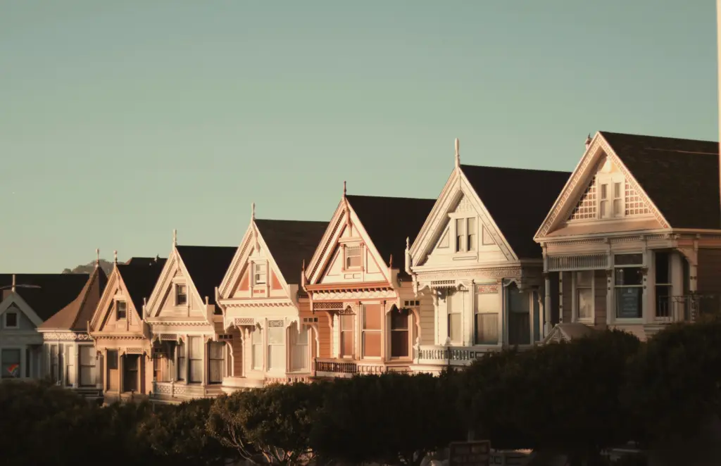 Row of classic Victorian homes at sunset symbolizing homeownership and retirement stability